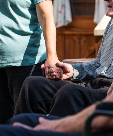 carer and resident holding hands