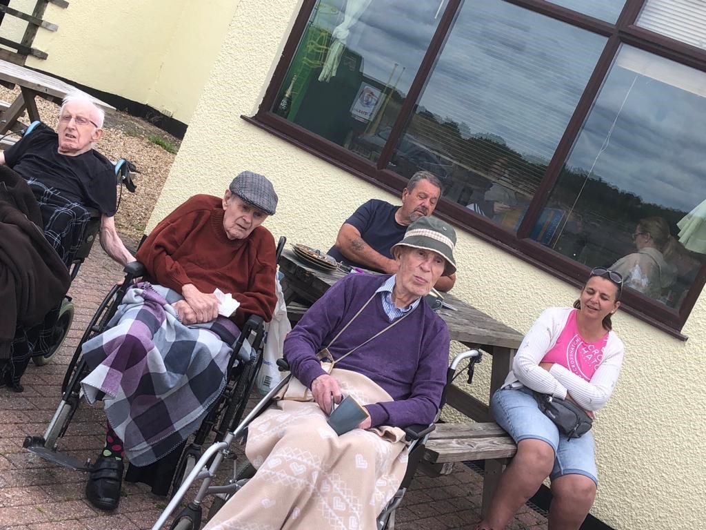 residents and staff sitting on bench