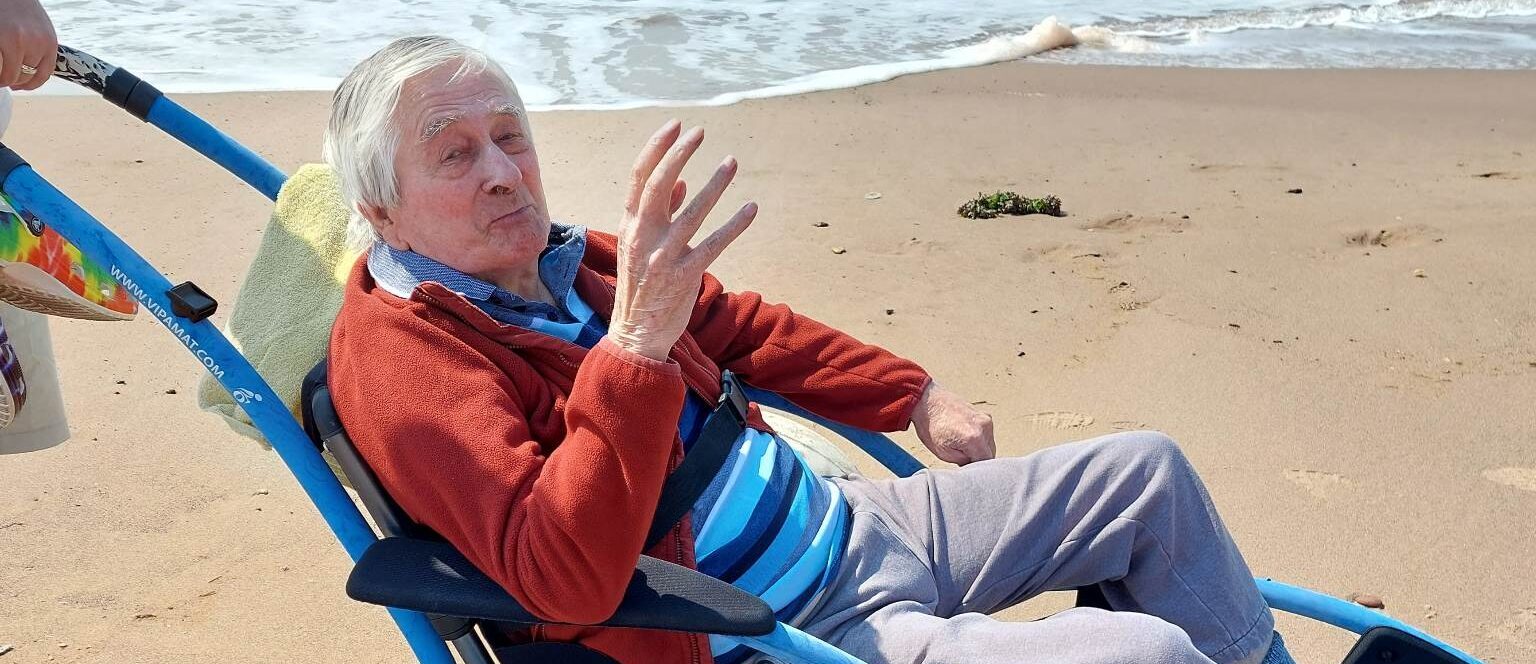 Edward Perryman waving while visiting Exmouth beach