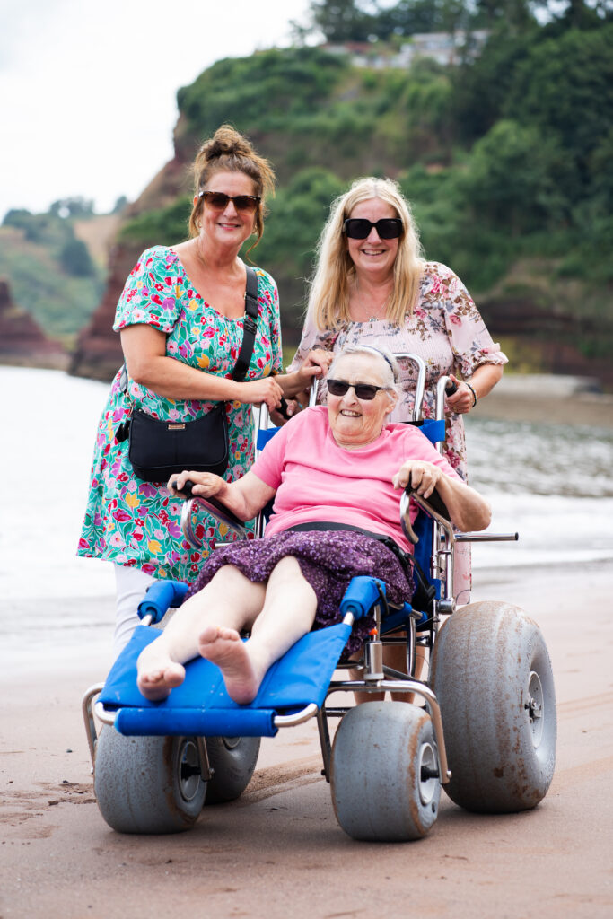 Members of the Sefton Hall care team at the beach in Dawlish with a resident