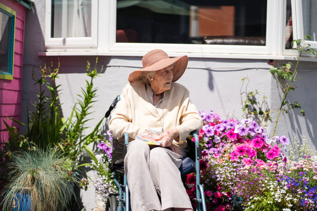 A resident enjoys sitting outside in the garden at The Seaton care home