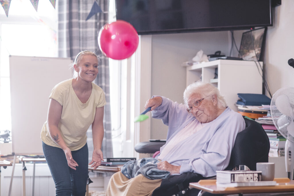 A resident takes part in balloon hockey at The Old Rectory care home, Exeter.