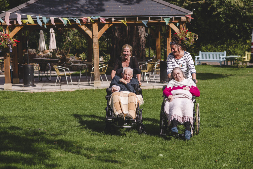 Residents and care team members enjoy some time in the garden at Sefton Hall