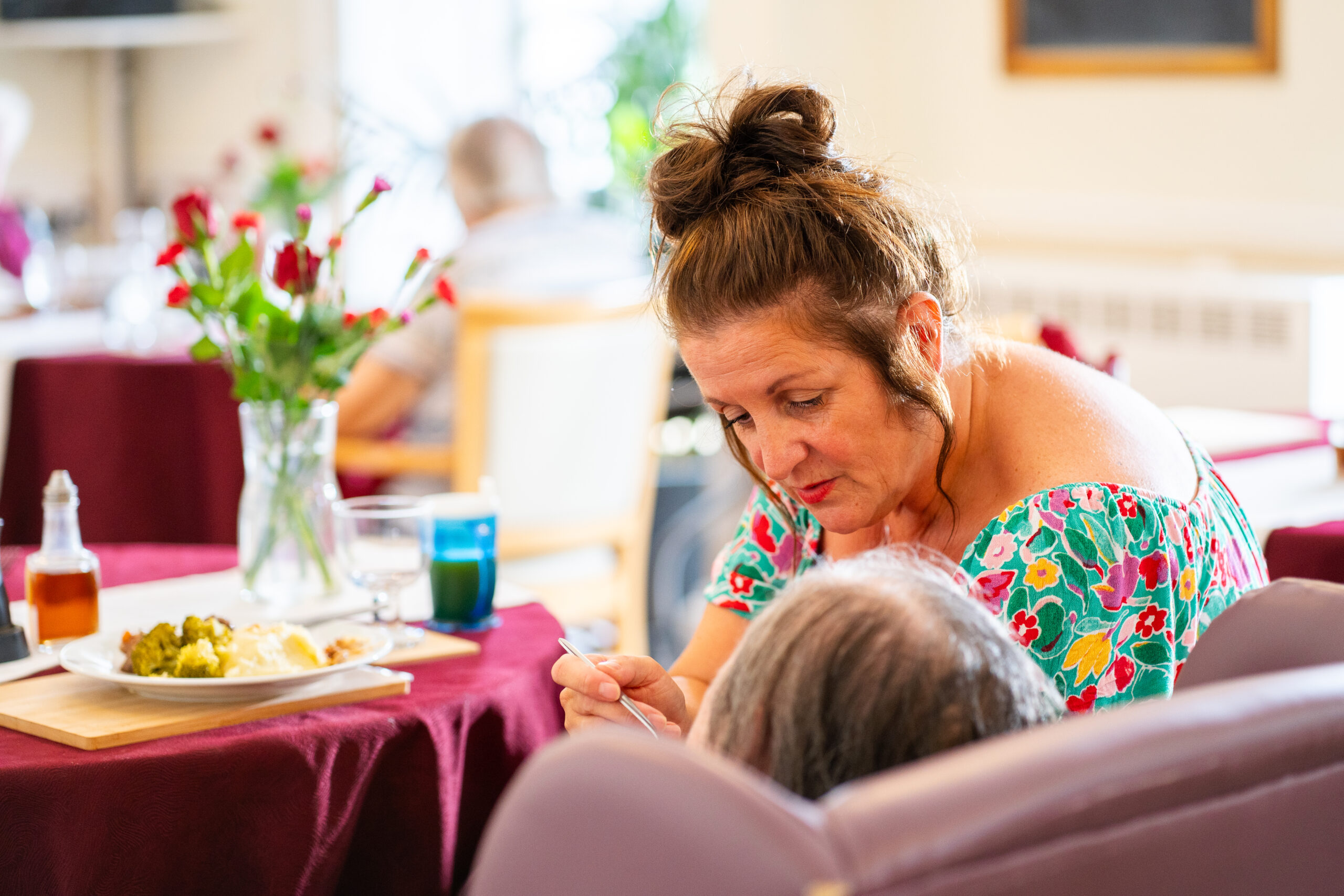 Sefton-Hall-care-team-member-Julie-Yates-helps-a-resident-eat-lunch