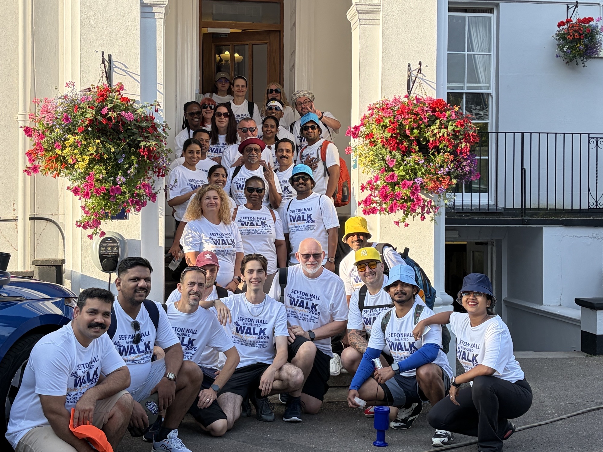 Southern Healthcare team members gather outside the entrance to Sefton Hall nursing home after their 15 mile walk