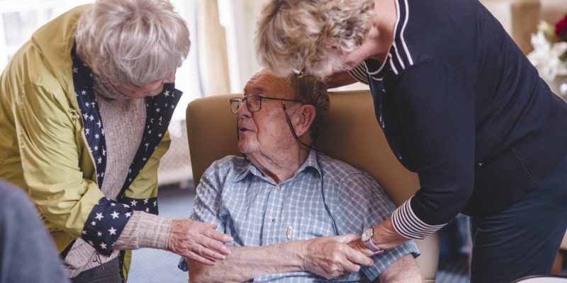A Sefton Hall resident enjoys time with family and friends in the lounge