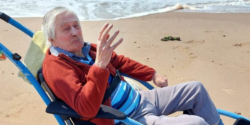 Edward Perryman waving while visiting Exmouth beach